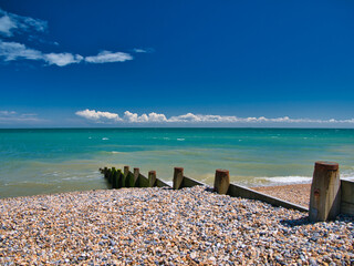 A wooden breakwater on the shingle beach in Kingsdown in Kent. Taken on a clear, sunny day with a...