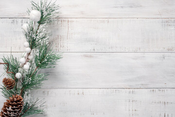 Christmas background with fir branches on the old white wooden board. Top view.