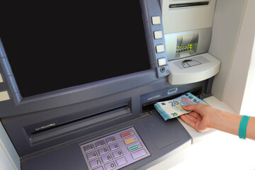 hand of the person who picks up european 20 Euro bills in an ATM of the bank