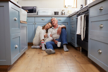 Coffee breakfast, relax and senior couple with smile on the kitchen floor in the morning in their...