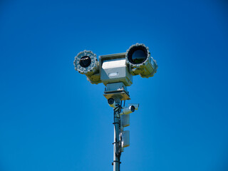 Fototapeta premium Remote controlled mobile surveillance cameras at the top of a tall mast at Dover point out across the English Channel. Taken on a sunny day in summer with a clear blue sky.
