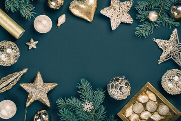 Merry Christmas and Happy New Year rich golden and crystal baubles festive ornaments. stars glitter and Christmas tree branches with cones on teal green. Party decor banner. Top view