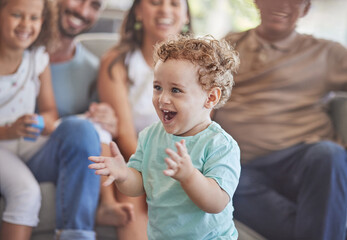 Baby, clapping hands and excited toddler boy feeling happy, playful and cheerful at home with his...