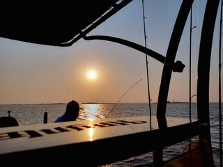 Older man fishing at sunrise