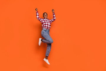 Full size portrait of overjoyed energetic person raise fists celebrate shout yes isolated on orange color background