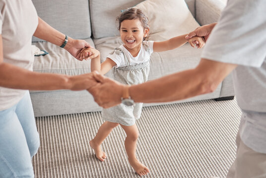 Happy Family, Child And Playing Circle Game While Bonding, Fun And Holding Hands With Energy, Happiness And Joy With Energetic Asian Girl. Kid, Play And Support With Man And Woman Doing Dance At Home