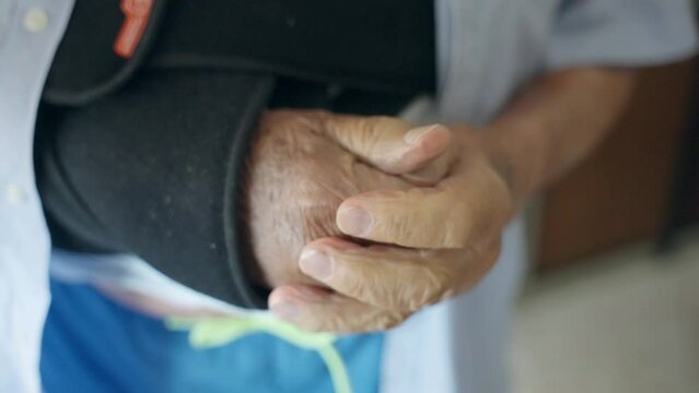 Elderly man suffering from bad blood circulation, senior person massaging and warming up his freezing hands, weak autoimmune system causing health problems, syndrome of anaemia of an old person