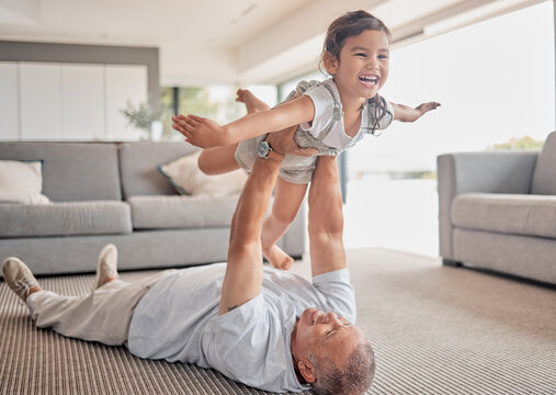 Love, happy grandfather and girl play in living room and laugh, fun and smile together. Grandparent lifting grandchild at home in lounge and enjoy bonding, carefree and relax on floor on weekend.