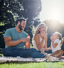 Family, happy and bubbles with picnic in park together for summer, relax and nature. Smile, spring and peace with parents playing with girl in countryside field for youth, lifestyle and happiness