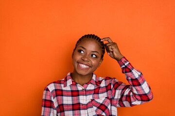 Photo of dreamy funny woman dressed plaid shirt looking empty space forget important thing isolated shine vibrant orange color background