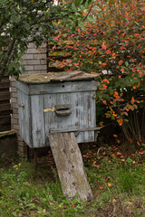 An old bee hive stands in an autumn garden