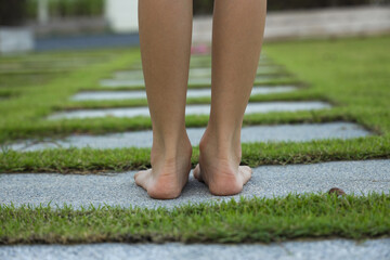 Barefoot little girl walking in garden path
