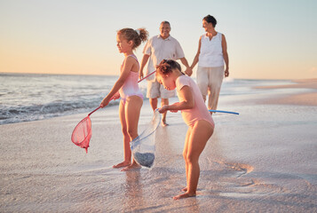 Grandparents and children at the beach with fishing nets and having fun. Young kids and senior...