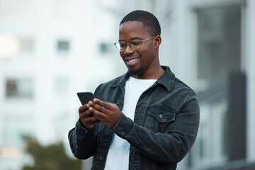Black man, phone and smile in city reading email, social media or blog on internet. Man, glasses and smartphone outside in Chicago happy with communication on mobile app via 5G web while outdoors