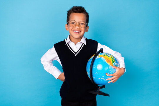 Portrait Of Positive Schoolchild Hand Hold Globe Toothy Smile Isolated On Blue Color Background