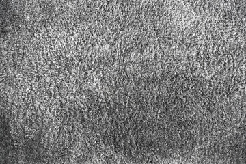 Grey soft fabric rug surface. Gray texture background of the furry carpet.
