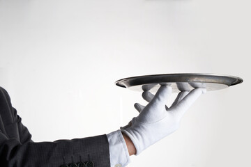 Elegant waiter hand in white glove holding an empty plate with white background.