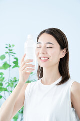 ペットボトルの水を飲む若い女性