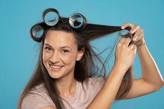 young woman putting curlers in her hair