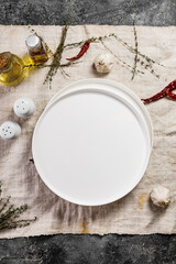 Empty white round plate. Top view. Linen tablecloth. Copy space. Vertical shot