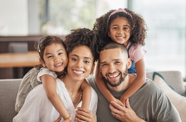 Happy, smile and portrait of an interracial family sitting on a sofa in the living room at home....