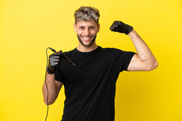 Tattoo artist caucasian man isolated on yellow background doing strong gesture