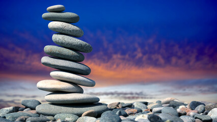 balance of stones on the background of nature. pyramid of smooth stones against a colored sky. natural balance of life.