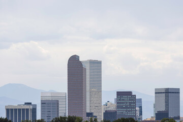 Fototapeta premium Denver skyline with mountains behind during daytime with copy space