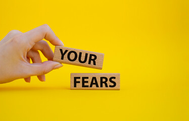 Your fears symbol. Wooden blocks with words Your fears. Beautiful yellow background. Businessman hand. Business and Your fears concept. Copy space.