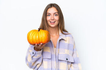 Young pretty woman holding a pumpkin isolated on white background with surprise and shocked facial expression