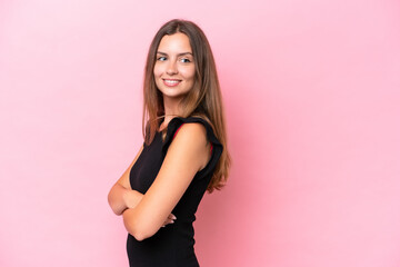 Young caucasian woman isolated on pink background looking to the side and smiling