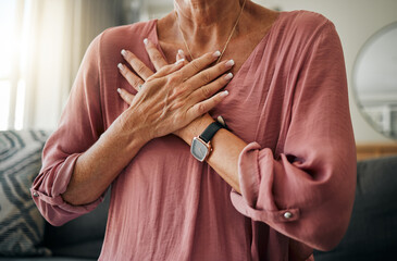 Senior woman, hands or chest pain in heart attack, anxiety or panic in house or home living room....