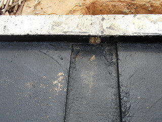 MELAKA, MALAYSIA -JULY 1, 2022: Waterproofing membrane applied by construction workers on top of the concrete slab. Waterproofing layer to prevent water from penetrating below the concrete slab. 
