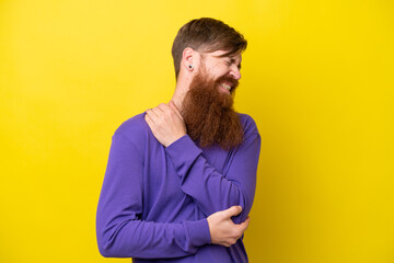 Redhead man with beard isolated on yellow background with pain in elbow