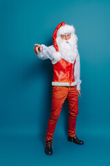 full size of Santa Claus pointing index finger aside isolated on blue background. New Year mock up