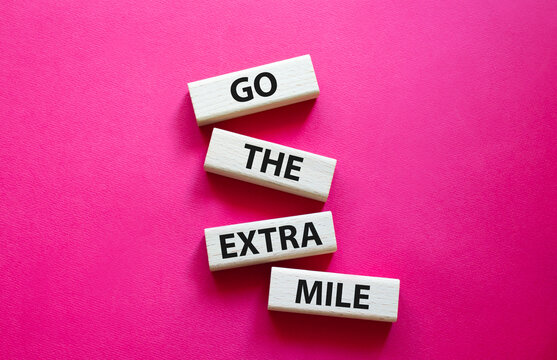 Go The Extra Mile Symbol. Wooden Blocks With Words Go The Extra Mile. Beautiful Red Background. Business And Go The Extra Mile Concept. Copy Space.