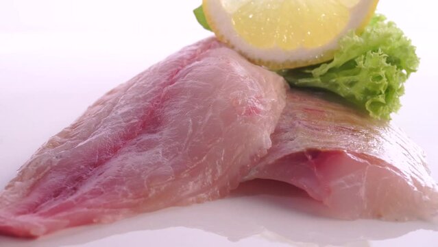 Raw Fish Fillet with Lemon turn around isolated on white Background