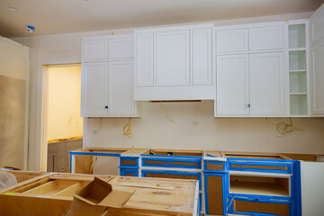 In newly constructed house, white kitchen cabinets and furniture were installed as part of interior decoration
