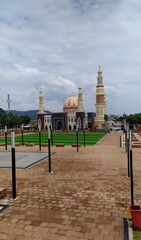 View of a mosque with a high dome and minaret with a beautiful city park