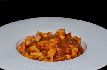 Chicken dinner in a white porcelain plate. Dinner plate isolated on black background.
