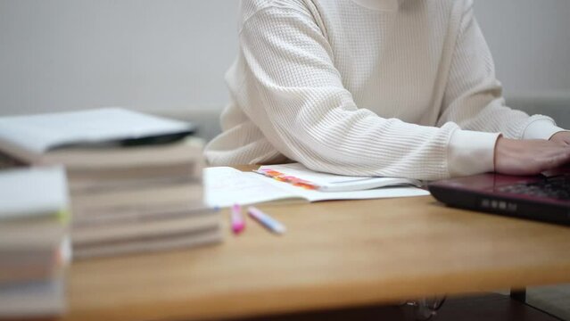 ノートパソコンを使って勉強する女性