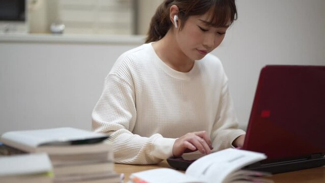 ノートパソコンを使って勉強する女性