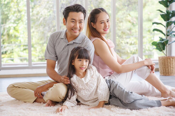 Real estate and mortgage concept : Family with child having fun in new home. Joyful first-time buyers in living room. Real estate, residential mortgage, moving into dream house.