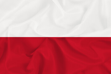 The national flag of the European country of Poland, the red and white flag of Poland on a wavy fabric background
