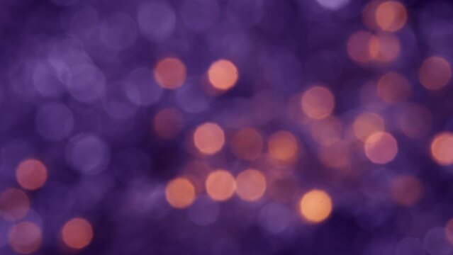 Abstract blurred glowing golden lights in slow motion. Violet bokeh Christmas and New Year background.