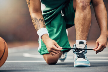 Basketball player shoes on court, start game and hands tie sneakers shoelaces with ball. Sports man prepare for competition, player training in summer and strong athlete kneeling ready for workout