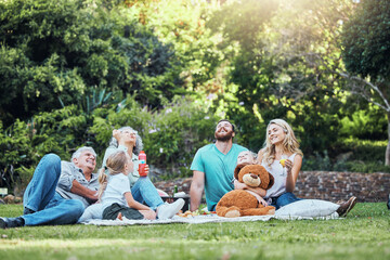 Happy, nature and big family on an outdoor picnic together in a green garden blowing bubbles....