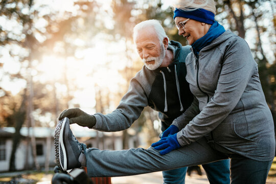 An older married couple enjoys exercising and jogging on a beautiful sunny winter day.