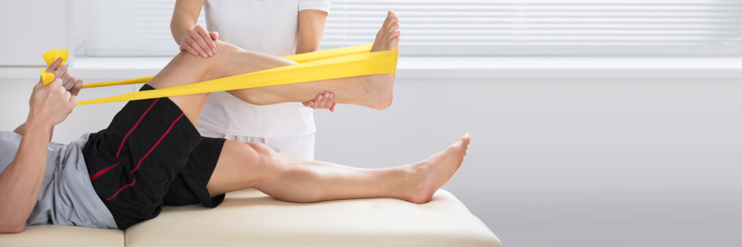 Physiotherapist Giving Treatment With Exercise Band