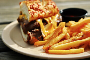 THE PRIME RIB DIPPER Food from applebee's restaurant served on a brown wooden table. sunny morning